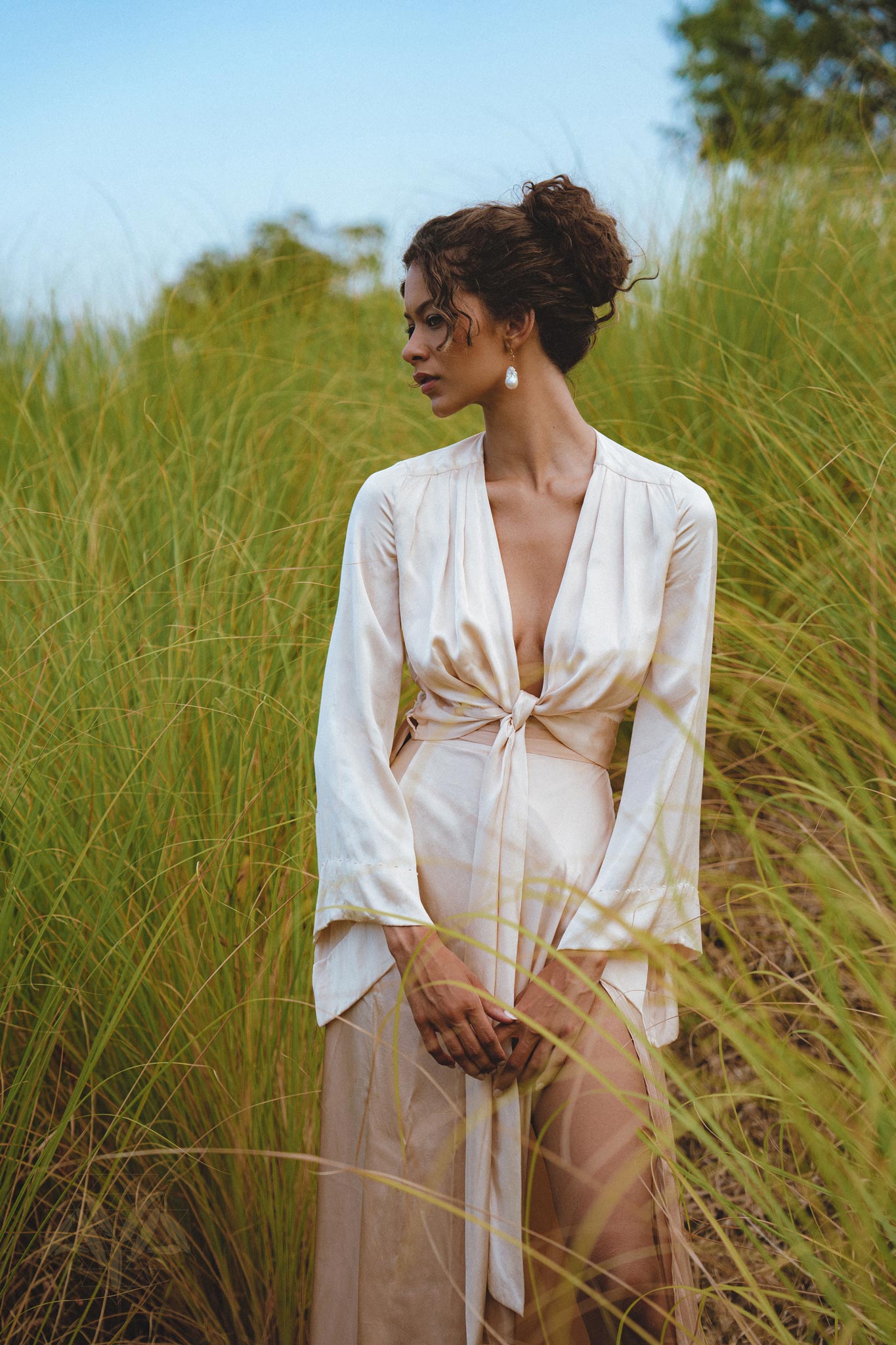 Elegant Powder Pink Venus Peace Silk Skirt displayed on a mannequin, showcasing its minimalist wrap design and soft, organic fabric, perfect for summer styling.