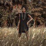 Stay cool and stylish in this black mini dress with ladder cut-outs and open sides.