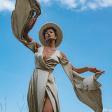 Capture attention with this ethereal light sage goddess dress. A graceful silk creation, perfect for bridesmaids or as a wedding guest dress. Be enchanted by its bohemian charm and billowing bell sleeves.