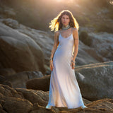Mist blue peace silk maxi slip dress made from organic Ahimsa silk, soft, breathable, and ethically produced without harming silkworms. This bohemian gown features delicate handmade brass angel wing details and a flowing silhouette that flatters the body. Lightweight and airy, it is perfect for summer, travel, ceremonies, weddings, or everyday luxury wear. Botanically dyed with natural pigments, each dress is unique, sustainable, and designed for comfort, elegance, and timeless feminine style.