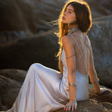 Mist blue peace silk maxi slip dress made from organic Ahimsa silk, soft, breathable, and ethically produced without harming silkworms. This bohemian gown features delicate handmade brass angel wing details and a flowing silhouette that flatters the body. Lightweight and airy, it is perfect for summer, travel, ceremonies, weddings, or everyday luxury wear. Botanically dyed with natural pigments, each dress is unique, sustainable, and designed for comfort, elegance, and timeless feminine style.