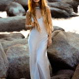 Mist blue peace silk maxi slip dress made from organic Ahimsa silk, soft, breathable, and ethically produced without harming silkworms. This bohemian gown features delicate handmade brass angel wing details and a flowing silhouette that flatters the body. Lightweight and airy, it is perfect for summer, travel, ceremonies, weddings, or everyday luxury wear. Botanically dyed with natural pigments, each dress is unique, sustainable, and designed for comfort, elegance, and timeless feminine style.