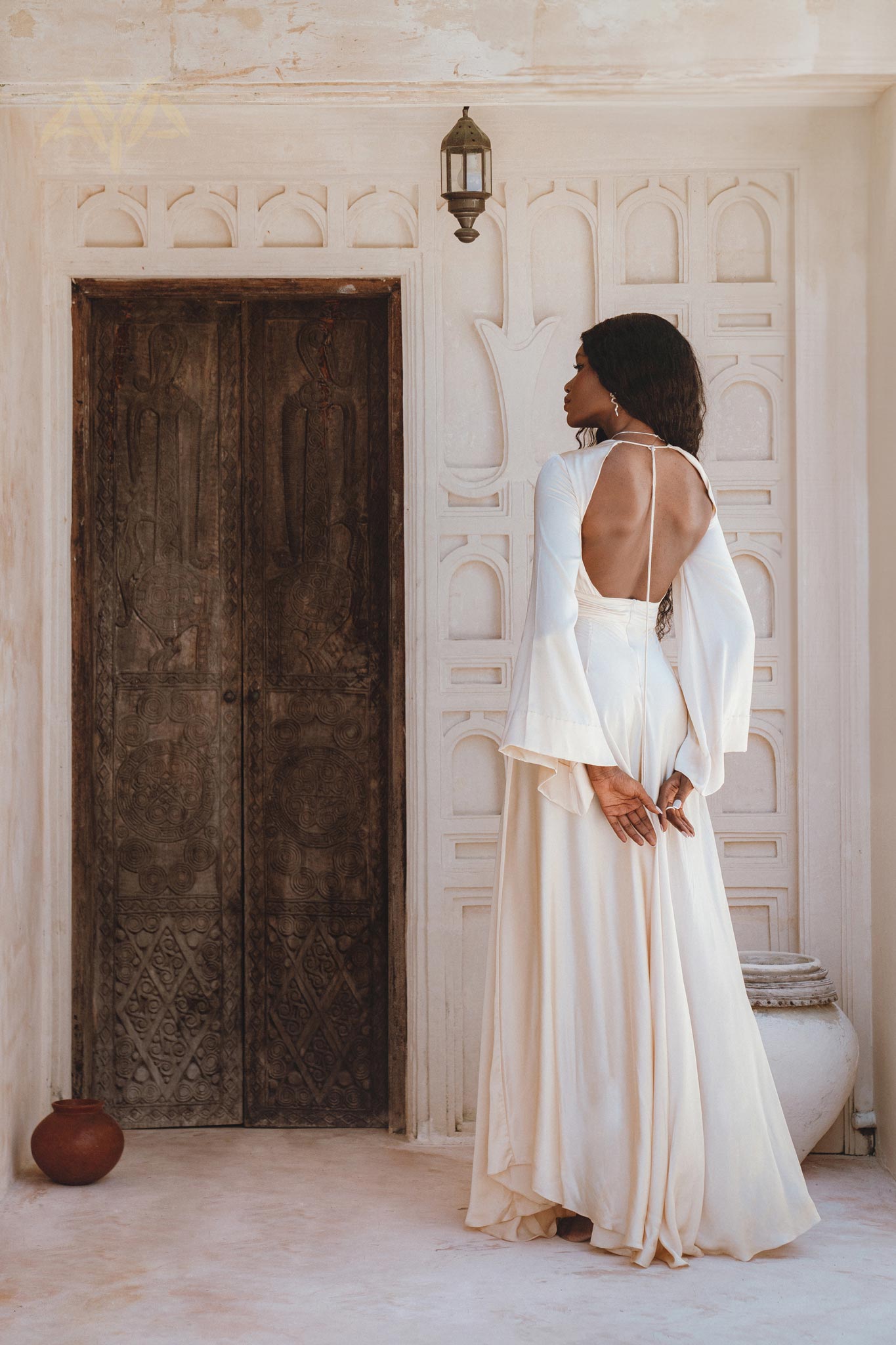 Channel your inner goddess in this off-white maxi dress, crafted from peace silk, adorned with bell sleeves and an alluring open back.