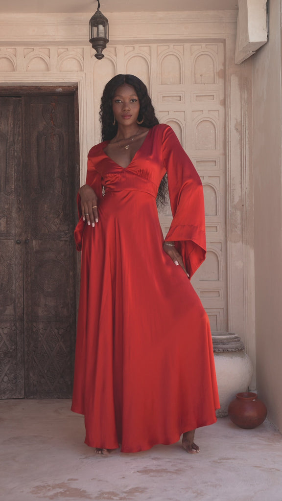 Elegant Peace Silk Maxi Dress in red, perfect for beach weddings, with an open back design and bell sleeves for a formal occasion.