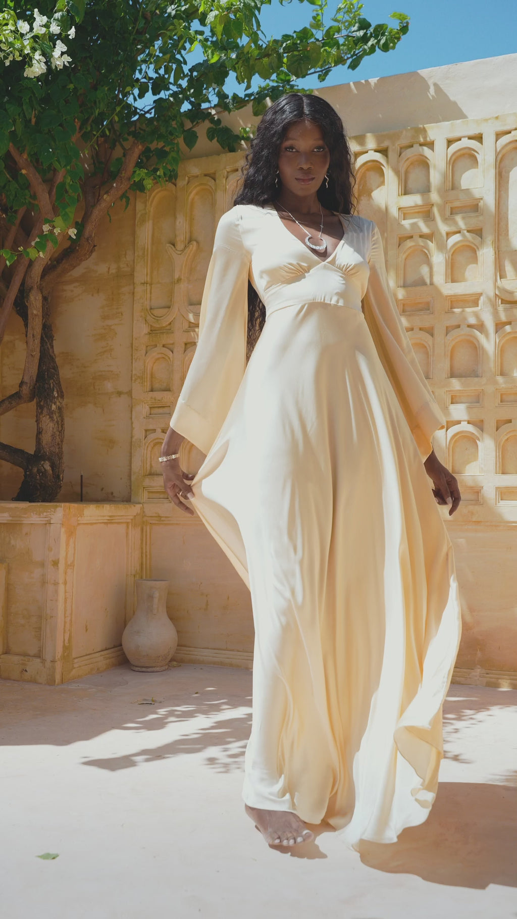 Elegant Off-White Cream Peace Silk Bridal Dress featuring Open Back & Bell Sleeves. Ideal for Beach Weddings, this maxi dress accentuates feminine grace.