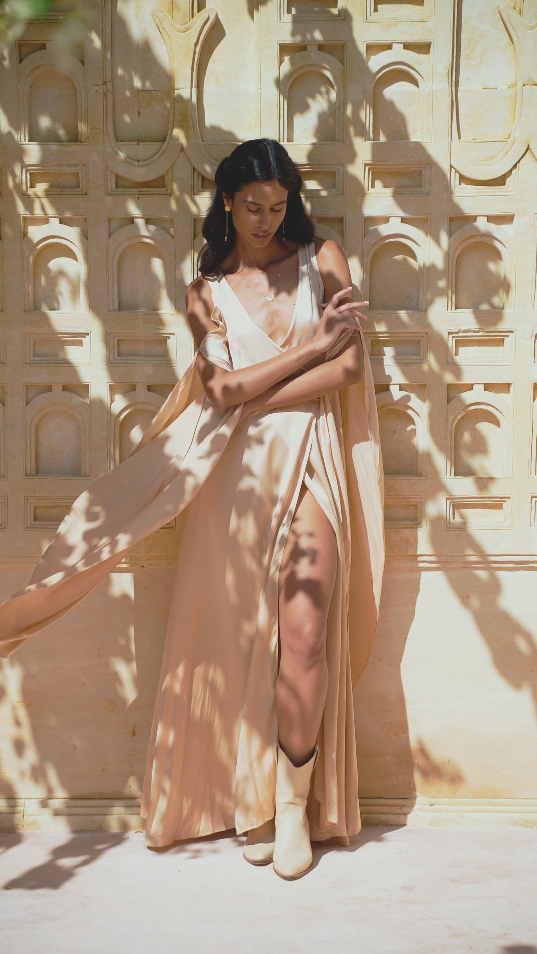 Silk wedding guest dress in light cream pink, designed as a goddess-inspired bridesmaid dress. Boho elegant wrap kimono with maxi bell sleeves.