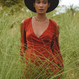 Make a statement as a wedding guest in this red wine boho dress featuring delicate bell sleeves.