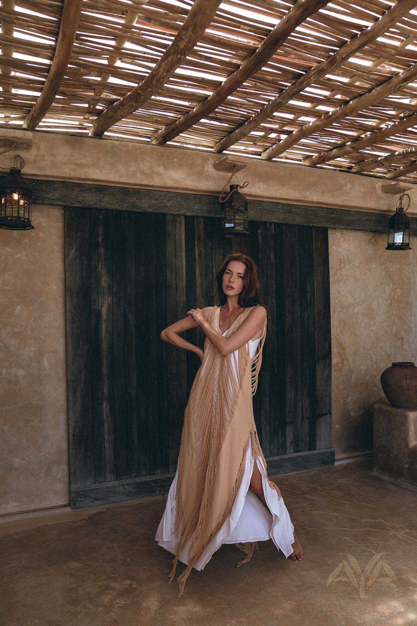 See-through beige ochre dress with hand-loomed tassel edging and open sides.